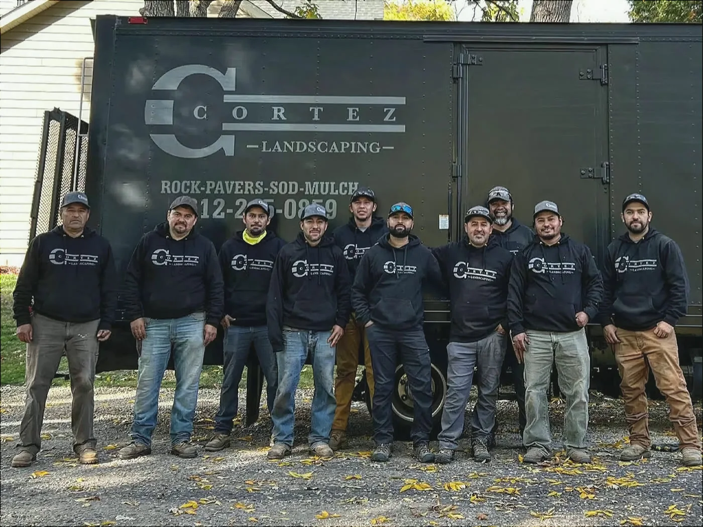 The Cortez Landscaping crew in front of their branded trailer