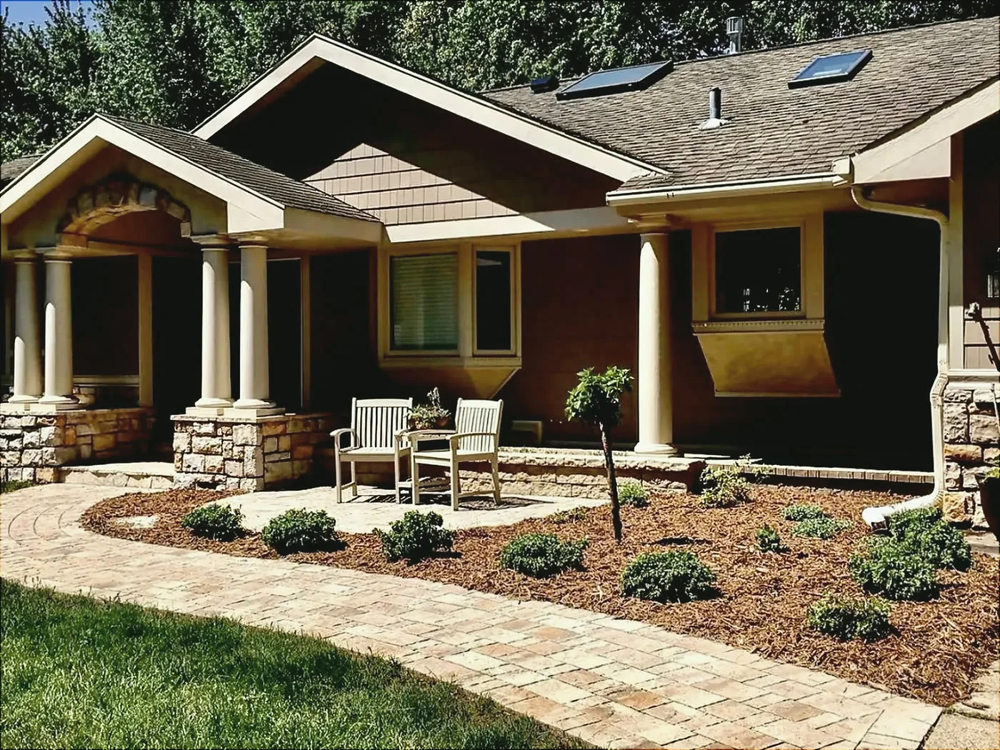 Curved paver front walkway with fresh mulch beds and new plantings